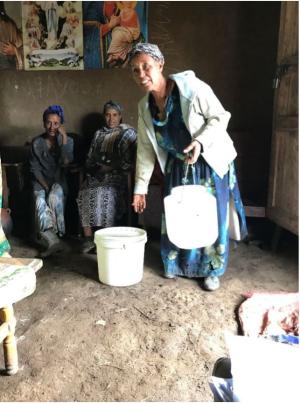Women using paint bucket for milk container